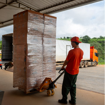Colaborador carregando pallet no centro de distribuição Colaborador carregando pallet no centro de distribuição